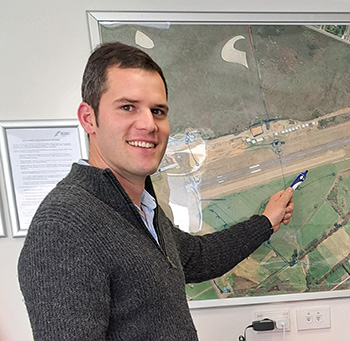 Man pointing at an aerial photo of a runway