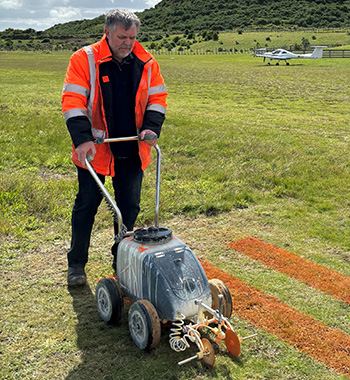 Man standing on grass with some contraption