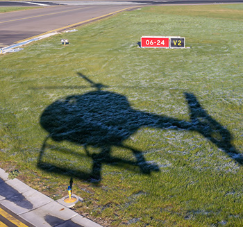 Shadow of a helicopter on the grass.