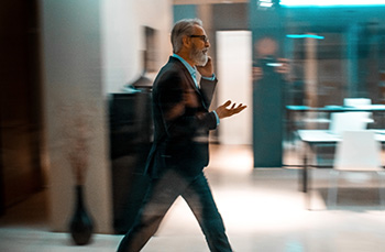 Bearded guy walking, talking on phone.