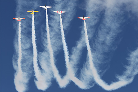 Five classic fighter planes climbing vertically