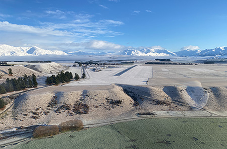 Snow covered landscape with mountains in the background