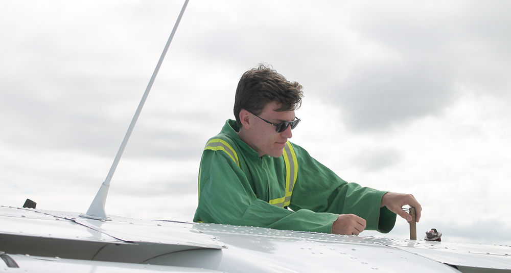 Man checking oil on plane