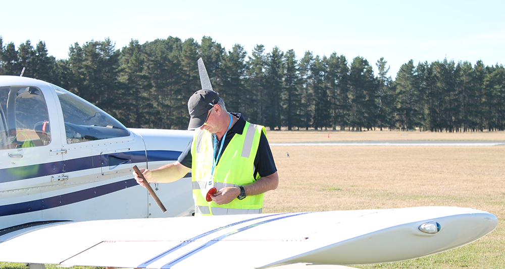 Man checking oil on plane