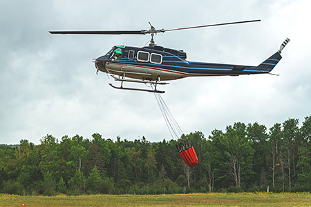 Helicopter with water bucket putting out fires