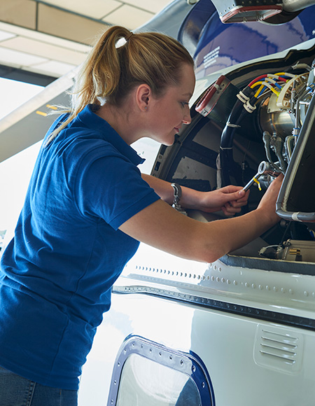 Female engineer working on a plane engine
