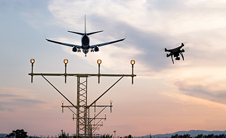Commercial plane and drone above power lines